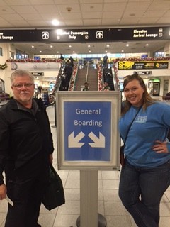 student and man pose in an airport