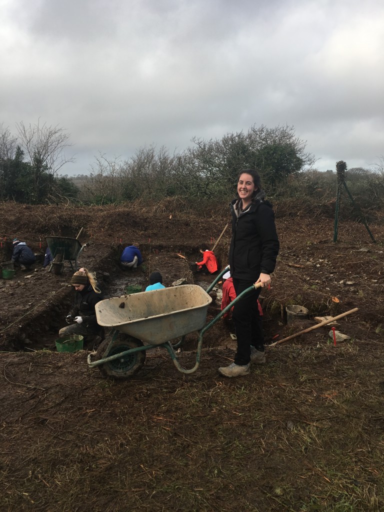 Ireland intern carries a wheelbarrow at her archeology dig site