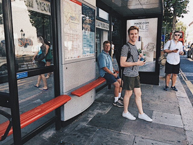 Picture of Joe waiting at a bus stop in London