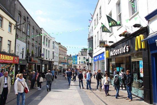 A busy pedestrian street in Dublin with many shops including a McDonalds