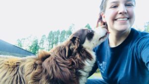 student getting licked on the cheek by a dog while smiling