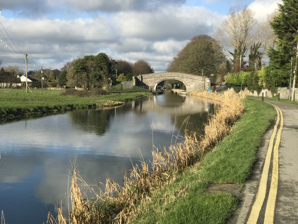 A canal in ireland goes under a stone bridge