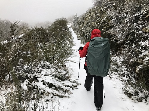 Michelle walking with her rucksack in the snow