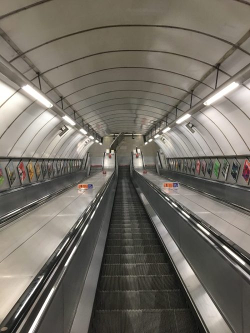 A long escalator leading to the Tube in London