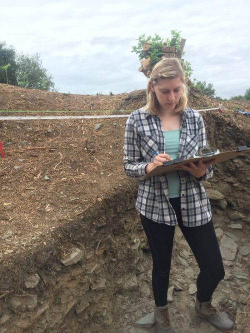Student takes notes while doing a dig at their archeology internship in Ireland