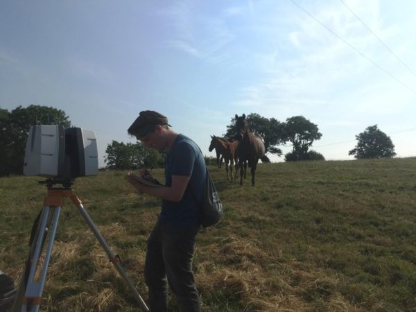 Archaeology interns working in the field with a Lidar scanner